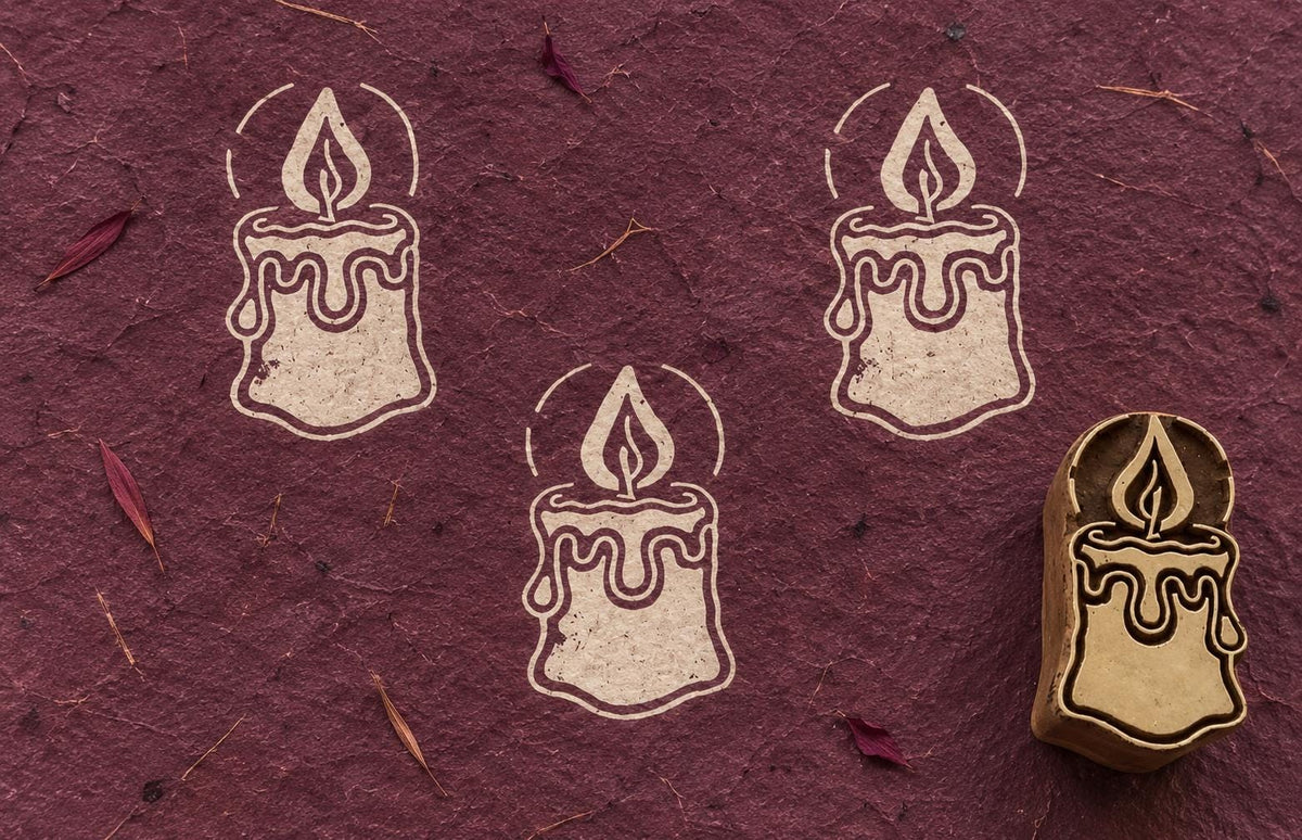 Wooden Christmas printing block featuring a decorative candle with flame and dripping wax, shown with repeated cream prints.