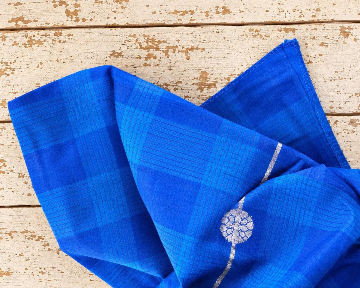 Draped cobalt blue fabric displaying its checked weave, sheen and silver detailing.