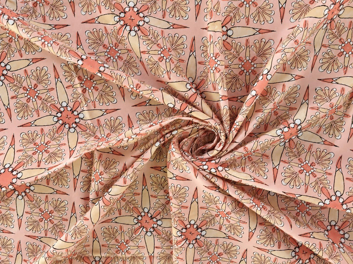 Peach Indian cotton fabric with Vintage Starburst hand block print shown in a flowing drape