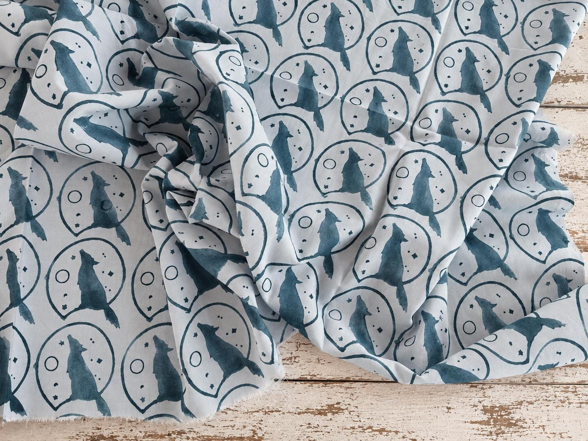 Soft mulmul cotton fabric with repeating Moonlit Wolf print shown in a flowing drape