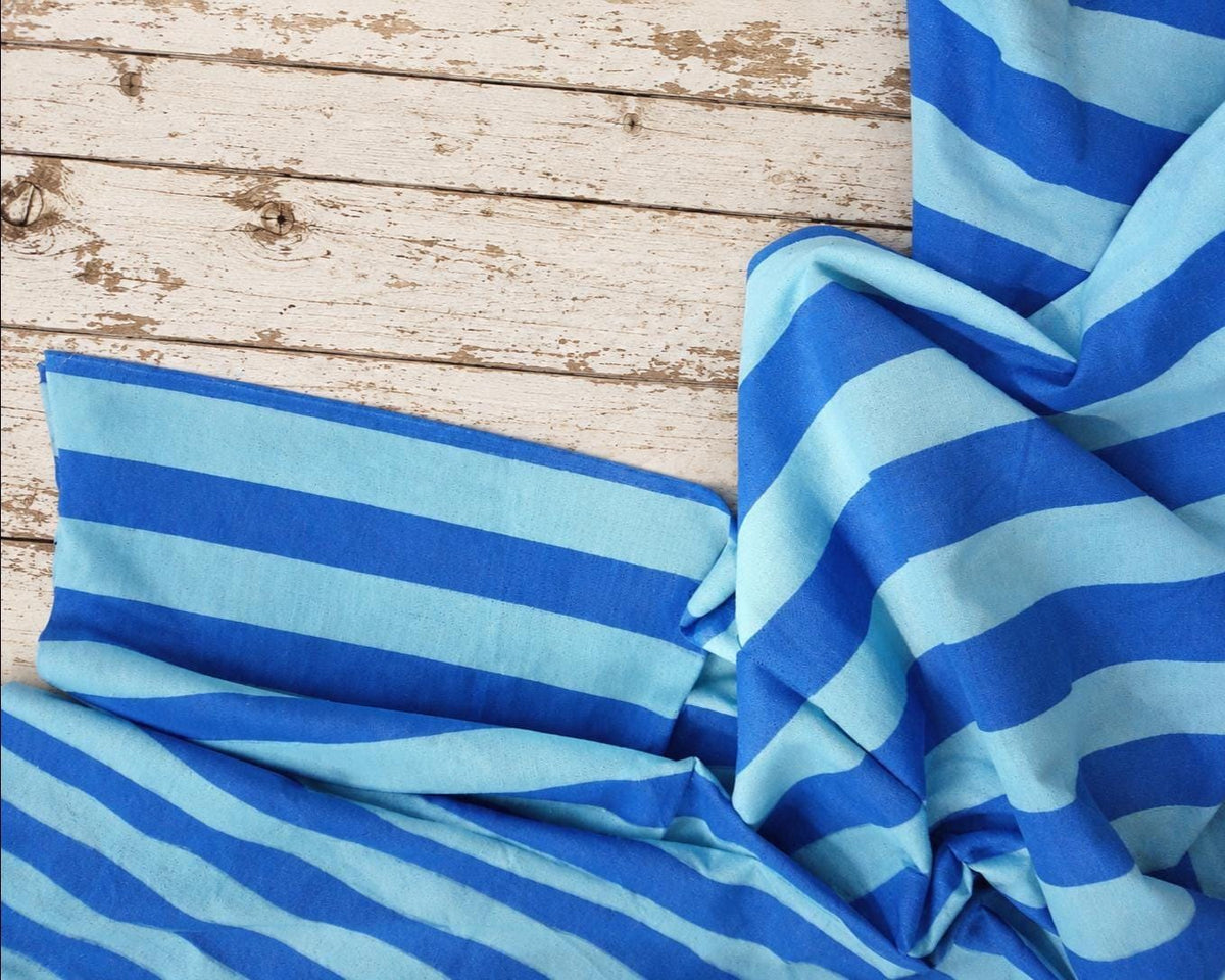 Azure Tide blue striped cotton fabric draped to show its pattern and natural folds.