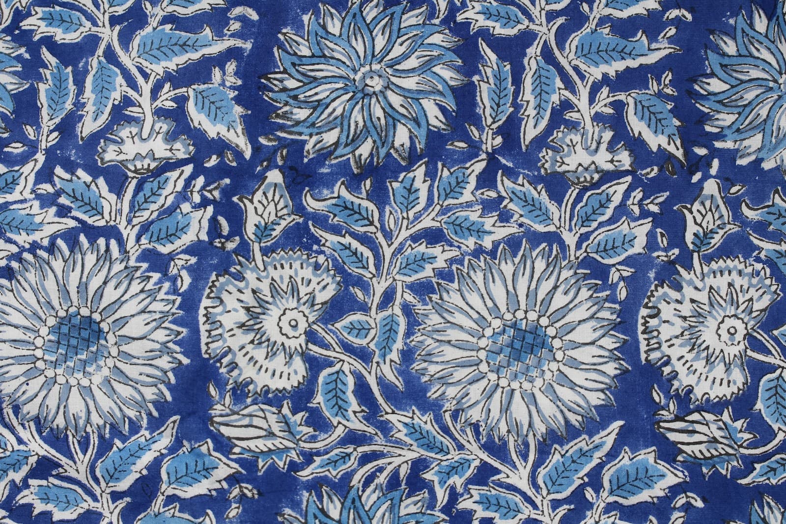 Close-up of Indigo Chrysanthemum Heritage cotton fabric showing chrysanthemum flowers, botanical leaves, and hand block printed details