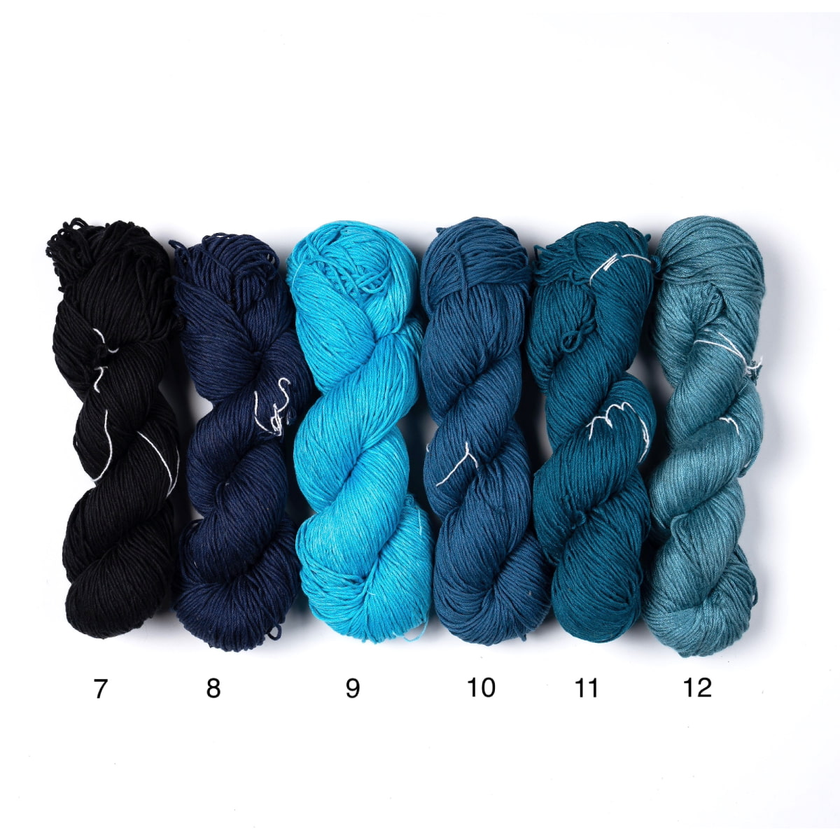 Mercerized Cotton Yarn – six shades in blue and black tones, soft mercerized cotton skeins.