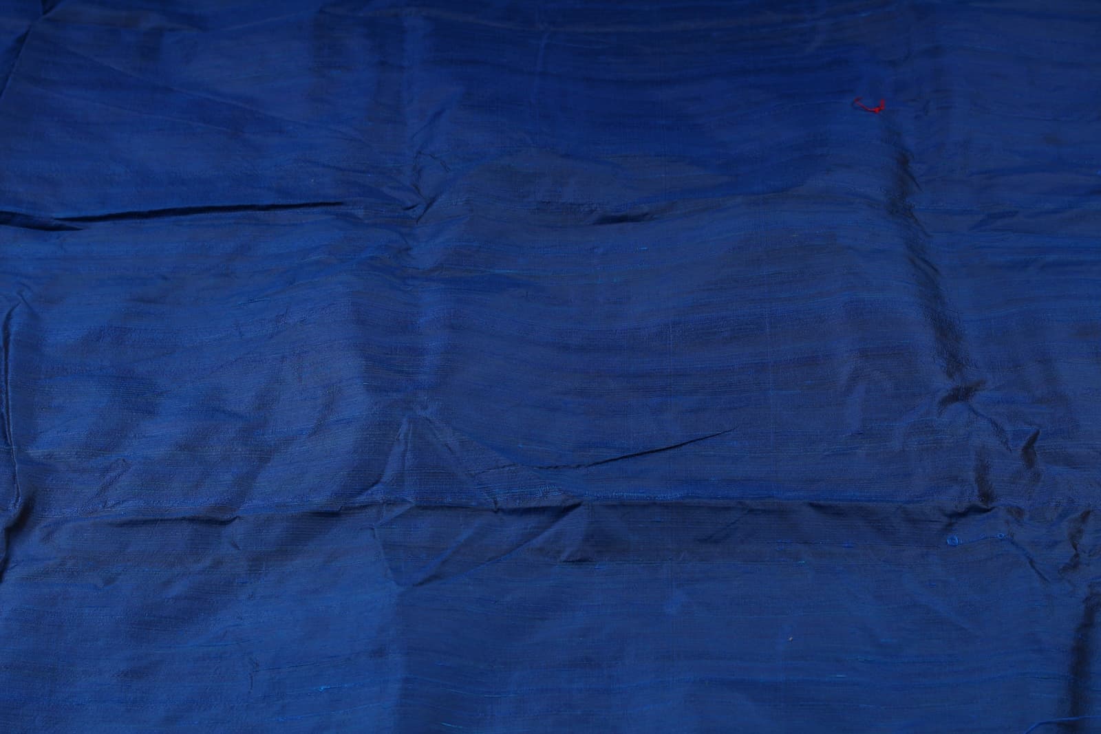 Midnight Blue Dupion Silk Fabric displayed in flowing folds showing its rich colour and luxurious silk sheen