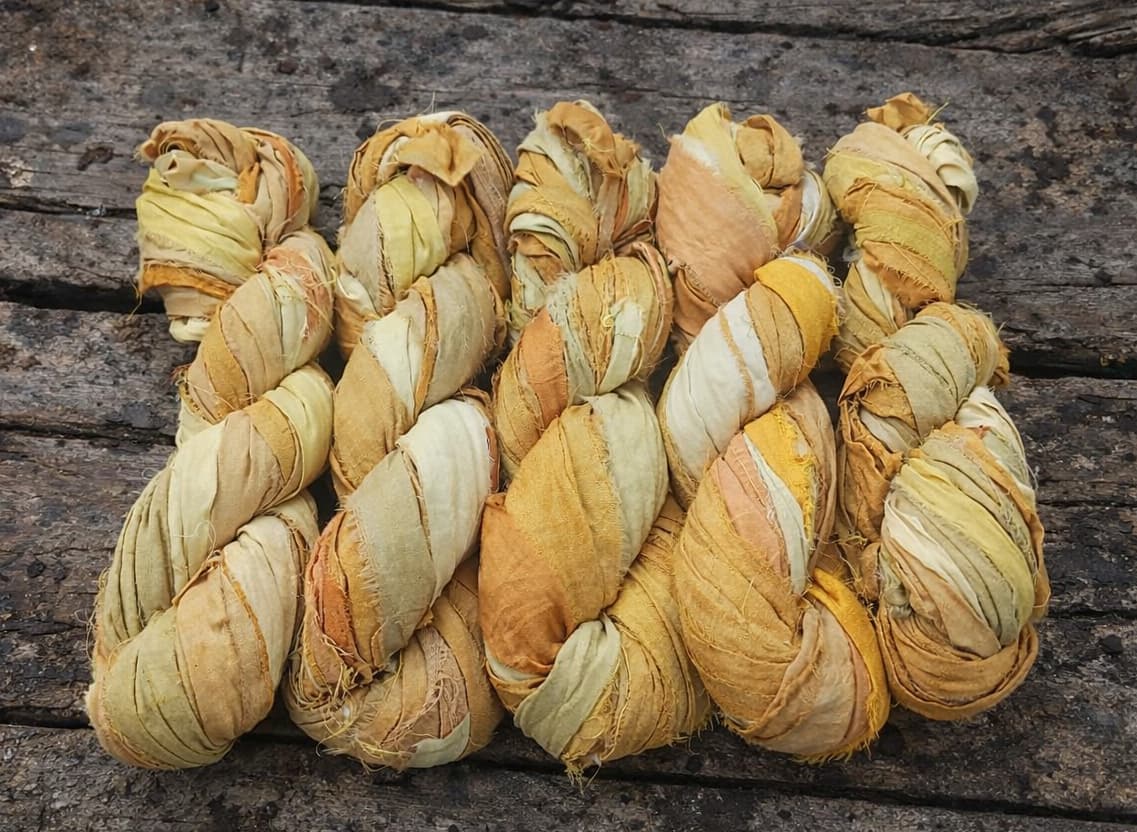 Golden Harvest sari silk ribbon yarn collection showing multiple hand tied skeins in golden yellow shades