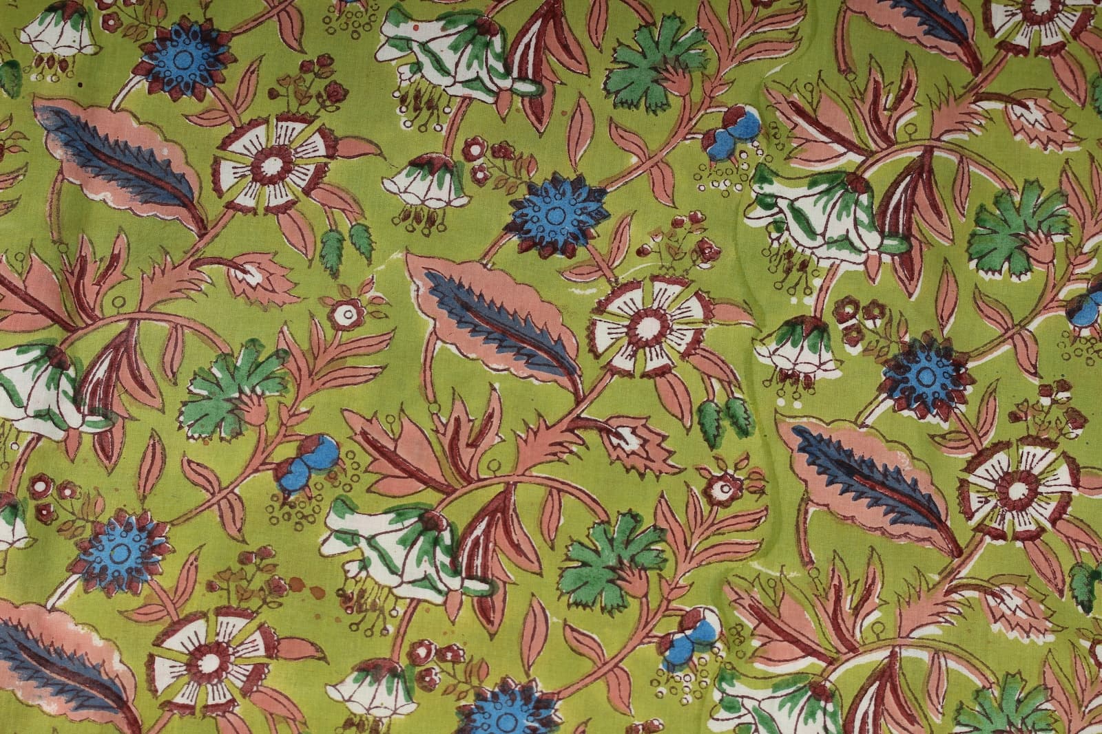 Close-up of Olive Woodland Wildflower fabric showing bell flowers, blue blooms, berries, leaves, and hand block printed botanical details