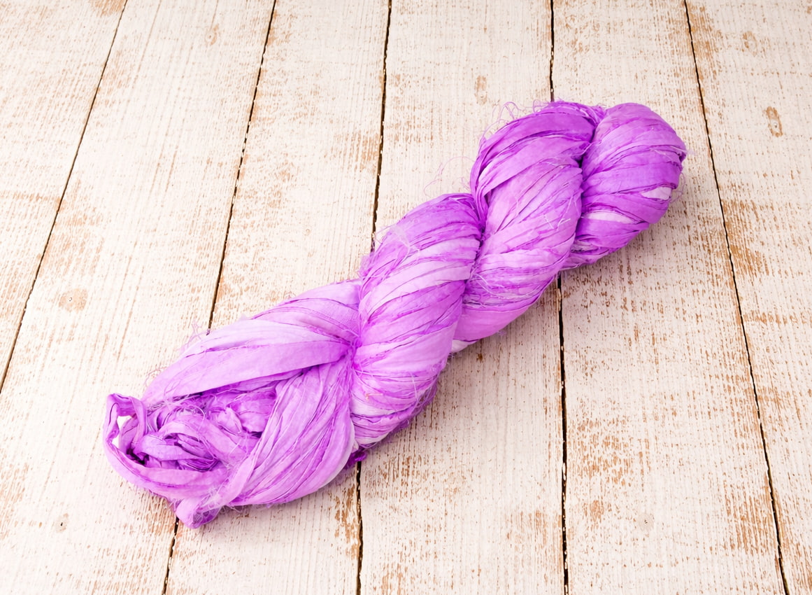 Single orchid sari silk ribbon skein in a soft pastel purple shade.