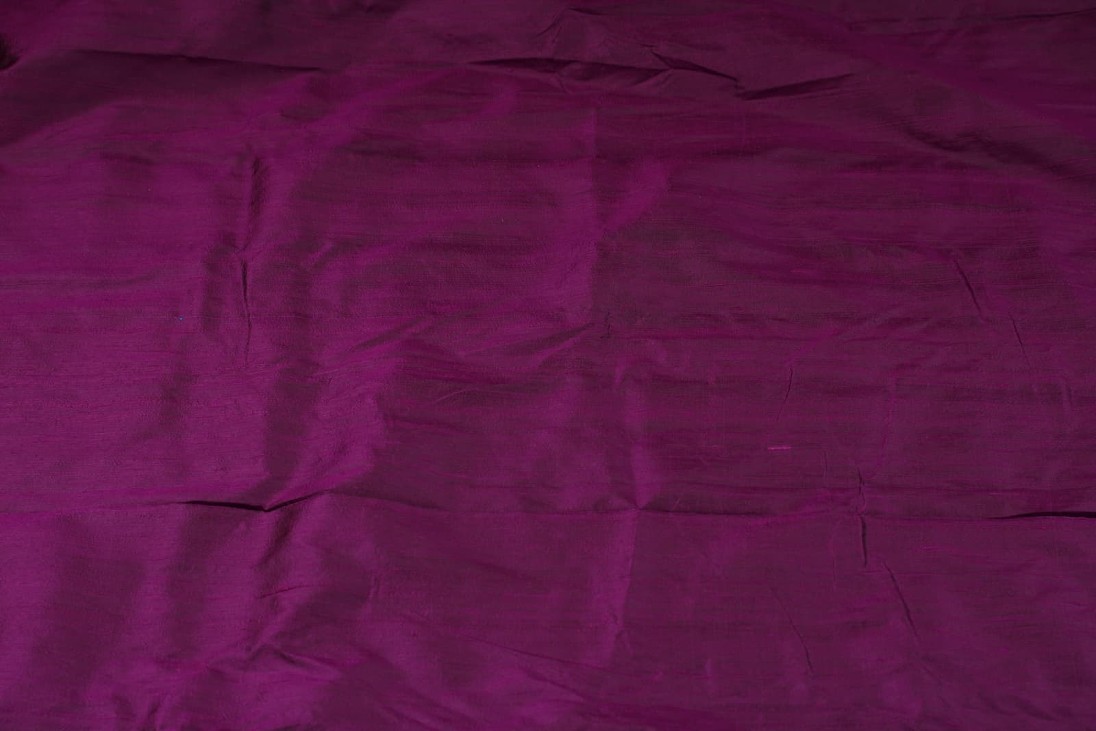 Plum Purple Dupion Silk Fabric laid flat displaying its luxurious colour, subtle sheen, and natural dupion silk texture