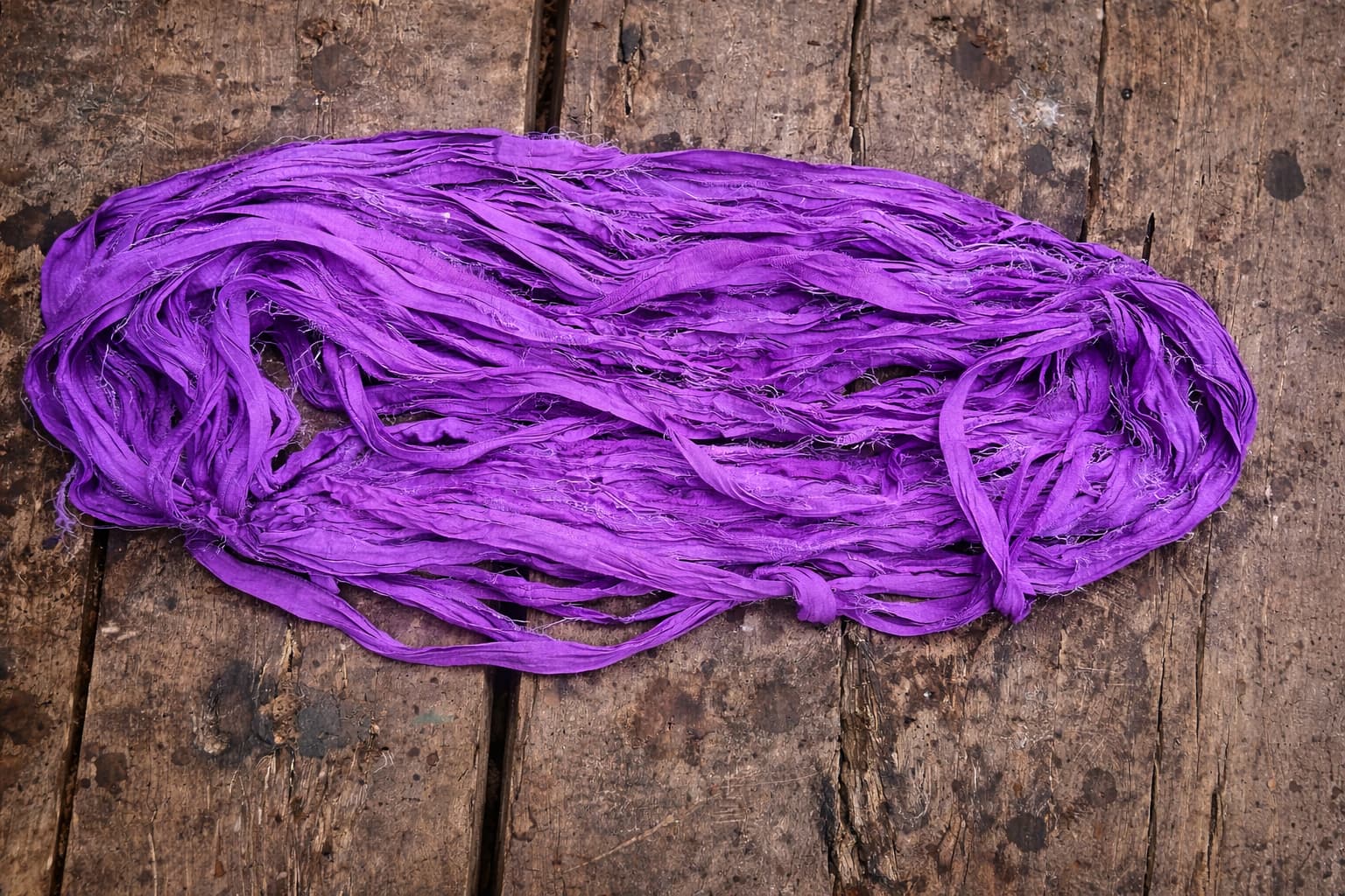 Loose hank of violet sari silk ribbon made from reclaimed sari silk.