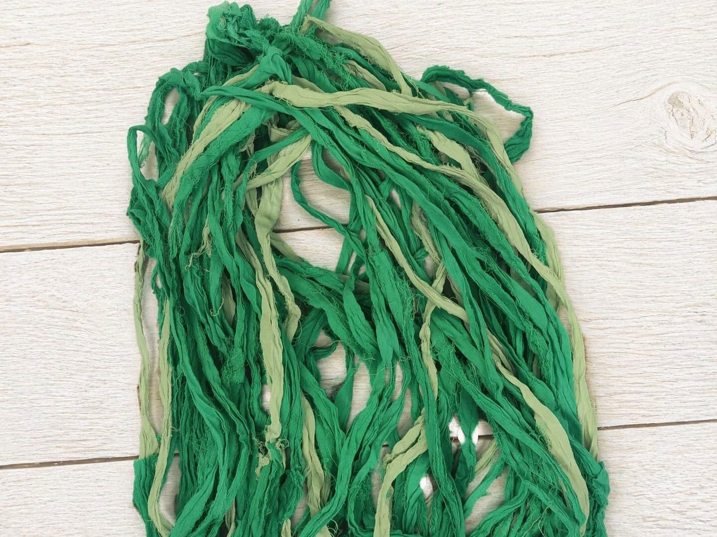 Close up of recycled silk ribbon strands in fern green and pale sage