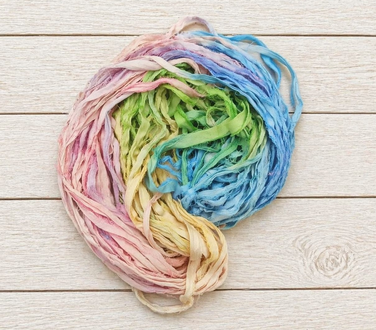 Coiled Pastel Meadow sari silk ribbon yarn showing multicolor pastel blend