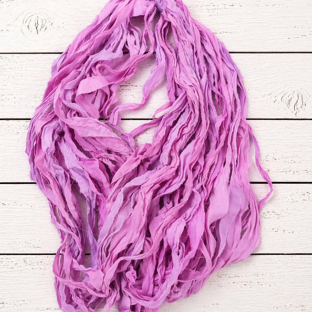 Full-length strands of Orchid Blossom chiffon silk ribbon yarn showing airy texture and soft drape