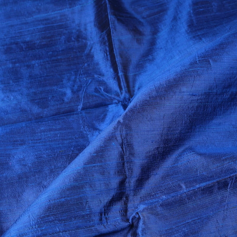 Royal Blue Dupion Silk Fabric displayed with soft folds revealing natural silk texture, lustrous finish, and rich jewel-blue colouring