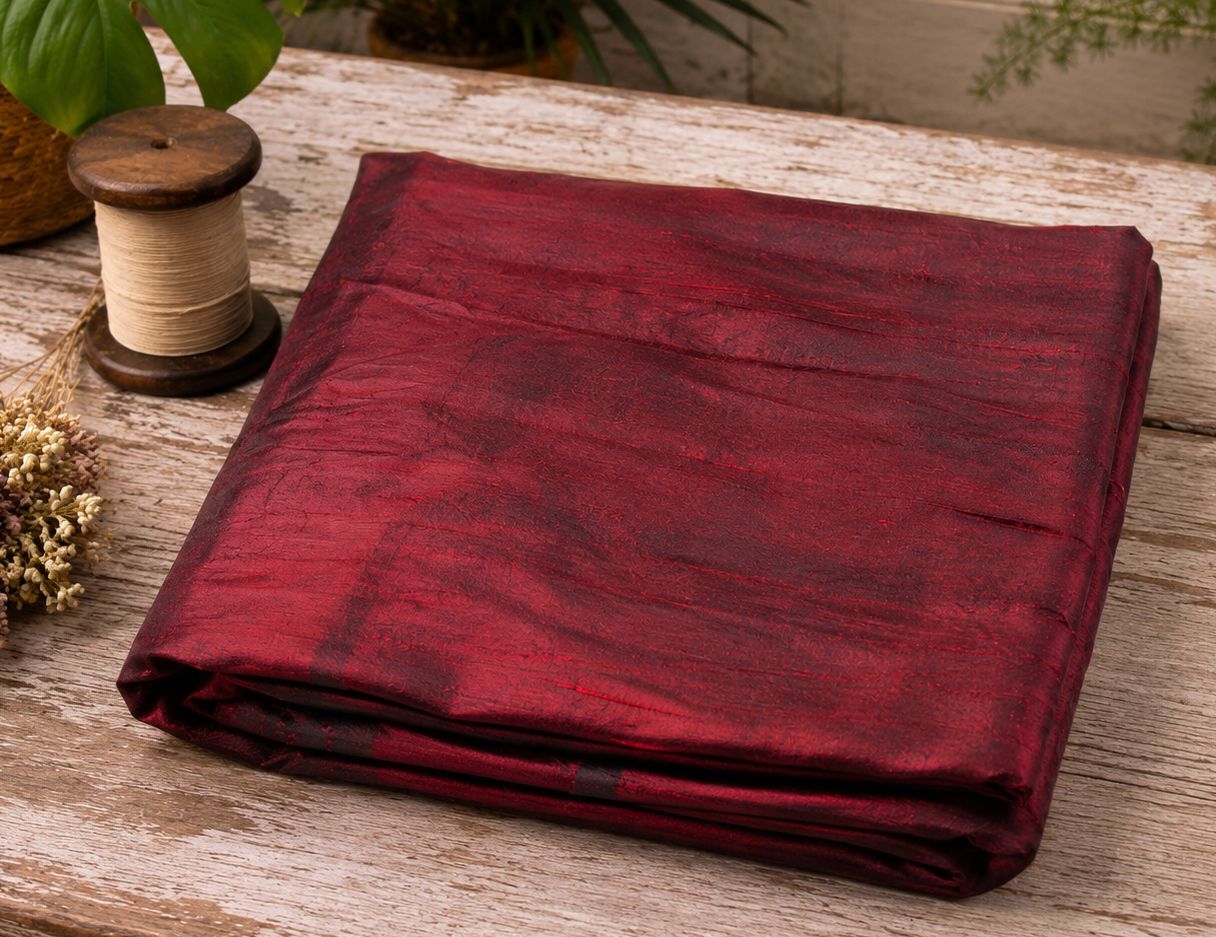 Folded ruby red Dupion silk fabric showing natural slub texture and silk sheen.