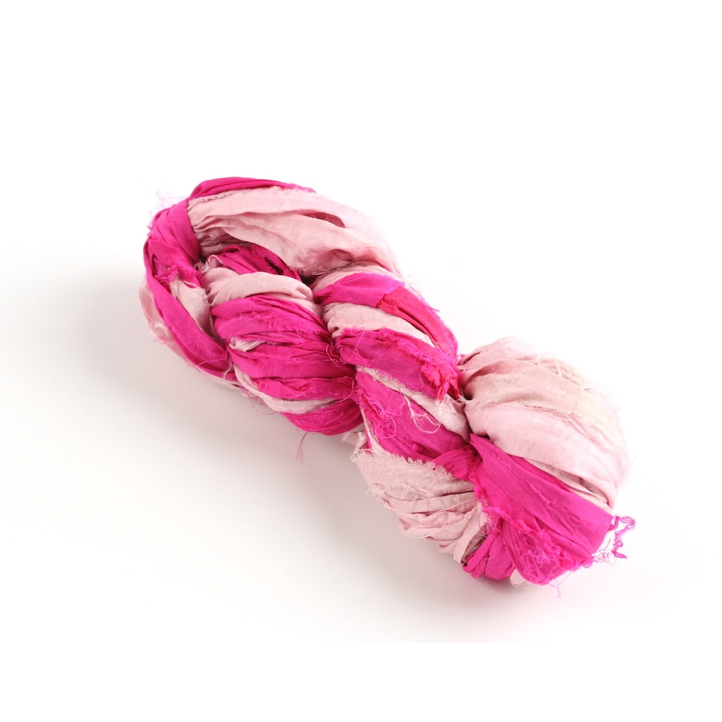 Dark and pastel pink sari silk ribbon skein on white background, handmade recycled silk ribbon for crafts.