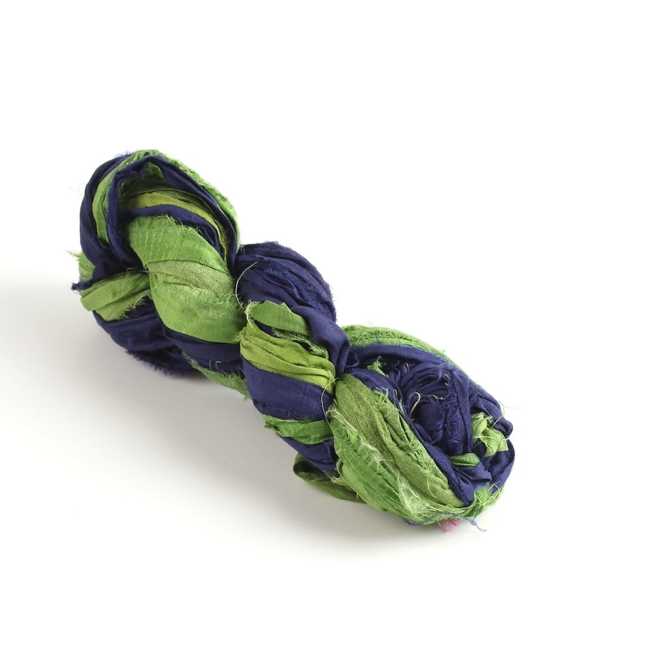 Green and blue sari silk ribbon skein on white background, handmade from recycled sari silk, eco-friendly craft ribbon.