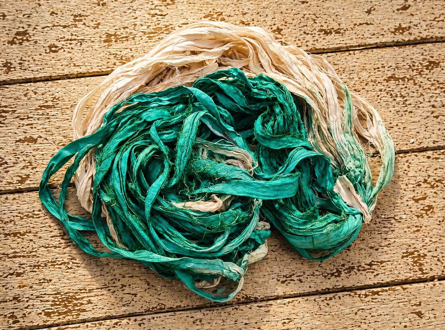 Coiled seafoam green and ivory silk ribbon yarn with soft texture