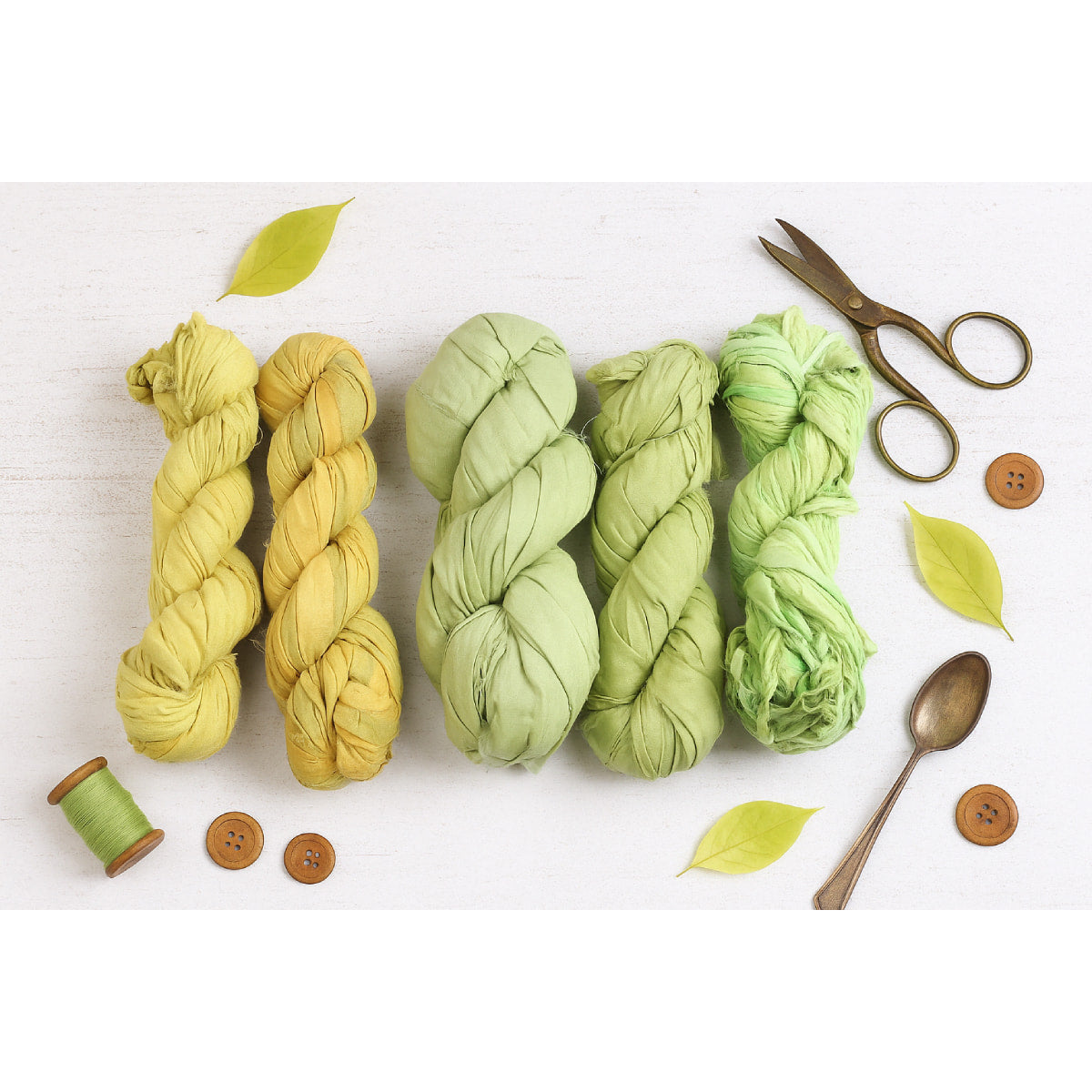 Assorted lime and green sari silk ribbons in various shades displayed together – handmade recycled silk ribbon collection