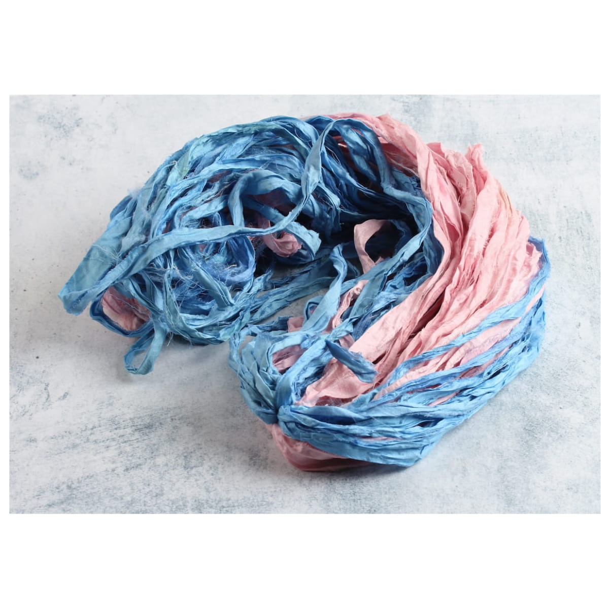Pastel pink and sky blue sari silk ribbon displayed open, showing texture and vibrant colors, ideal for gift wrapping, DIY, and crafts.