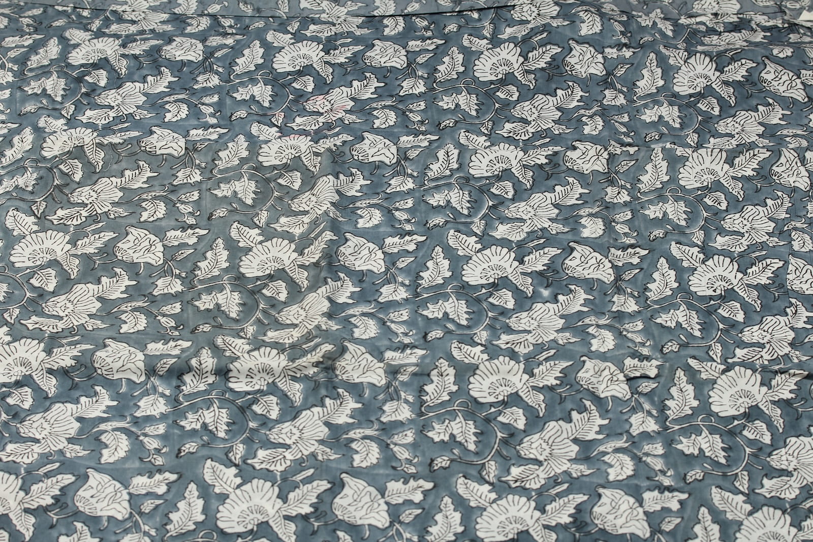Slate Meadow Bloom hand block printed cotton fabric featuring ivory floral vines and botanical motifs on a slate blue background
