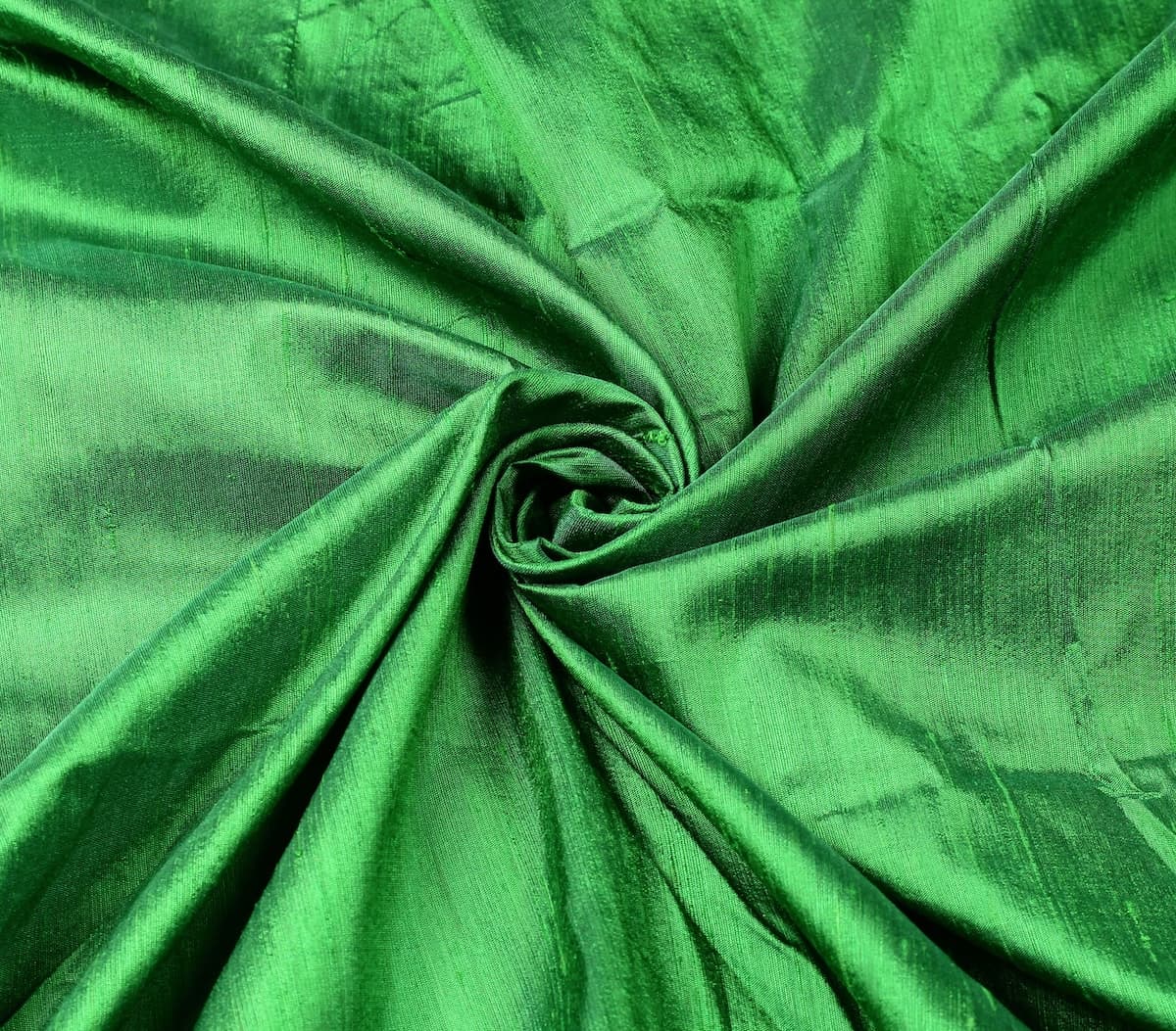 Spring Green Dupion Silk Fabric arranged in elegant swirling folds highlighting its lustrous sheen, crisp texture, and vibrant green tones