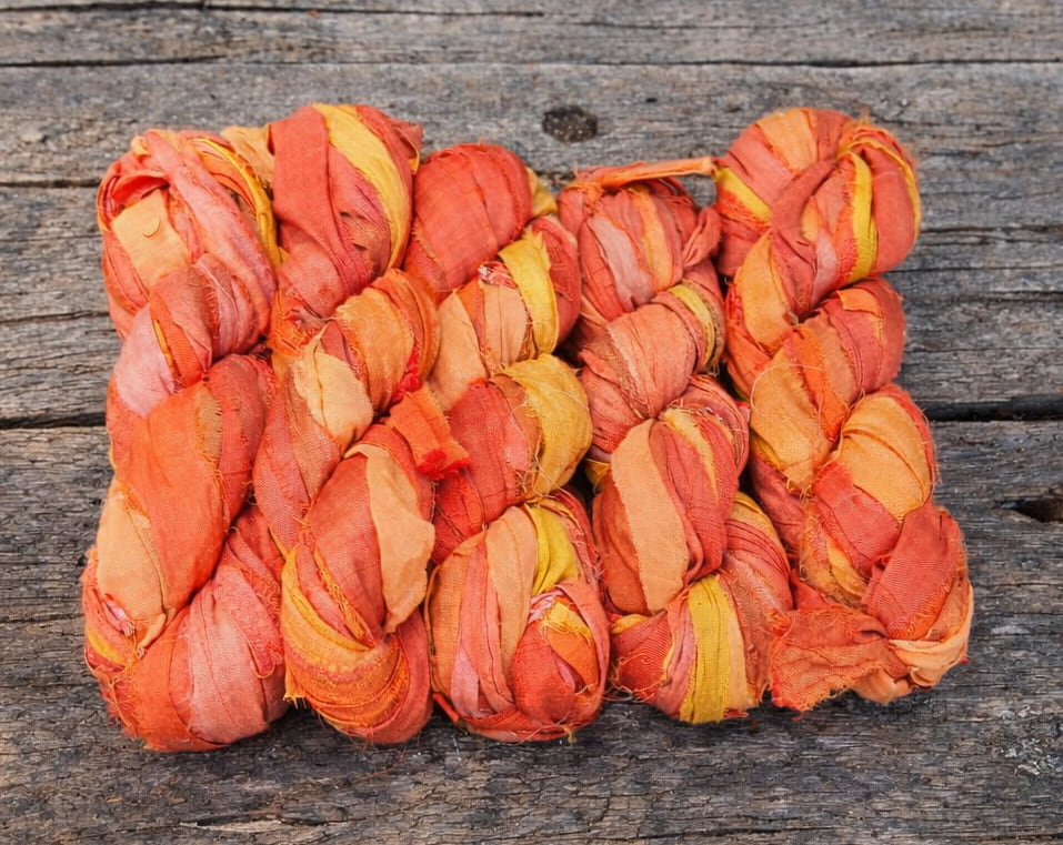 Bundle of Sunset Mango sari silk ribbon skeins made from recycled sari silk fabric.