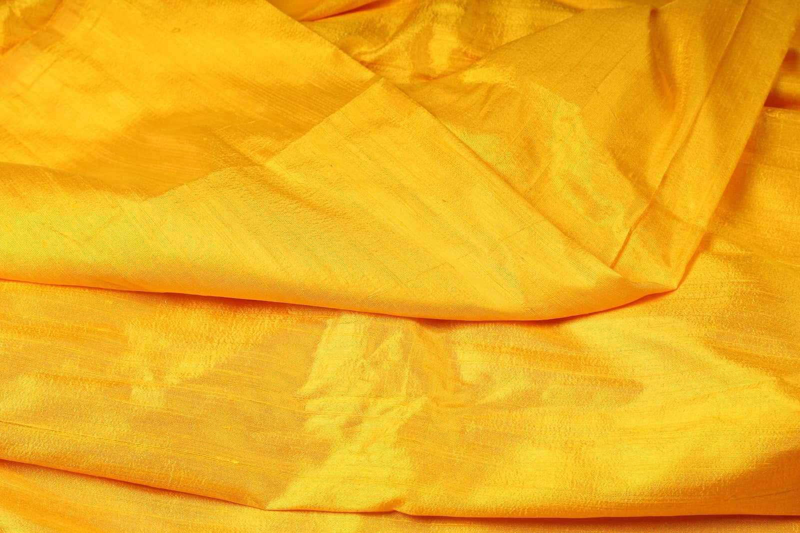 Golden Yellow Dupion Silk Fabric displayed with soft folds revealing natural silk texture, luminous finish, and rich golden-yellow tones