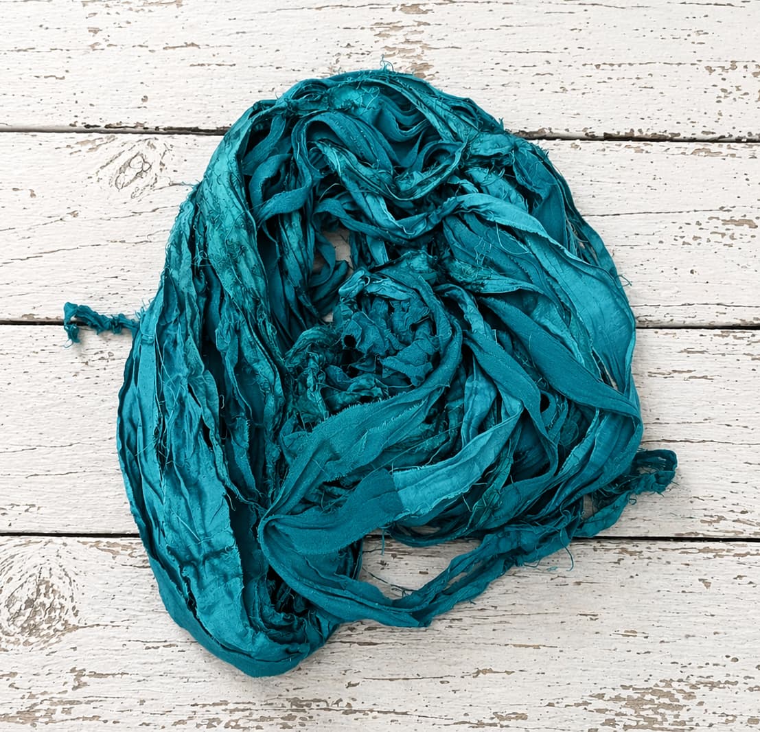 Loose bundle of Peacock Lagoon sari silk ribbon yarn showing vibrant turquoise tones