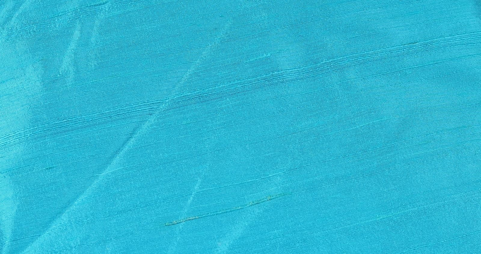 Close-up of Turquoise Dupion Silk Fabric showing natural slub texture, woven silk detail, and subtle colour variation