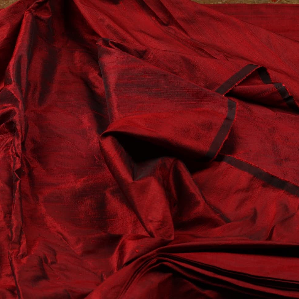 Bordeaux Red Dupion Silk Fabric displayed in flowing folds showing its rich jewel-toned colour and luxurious silk sheen