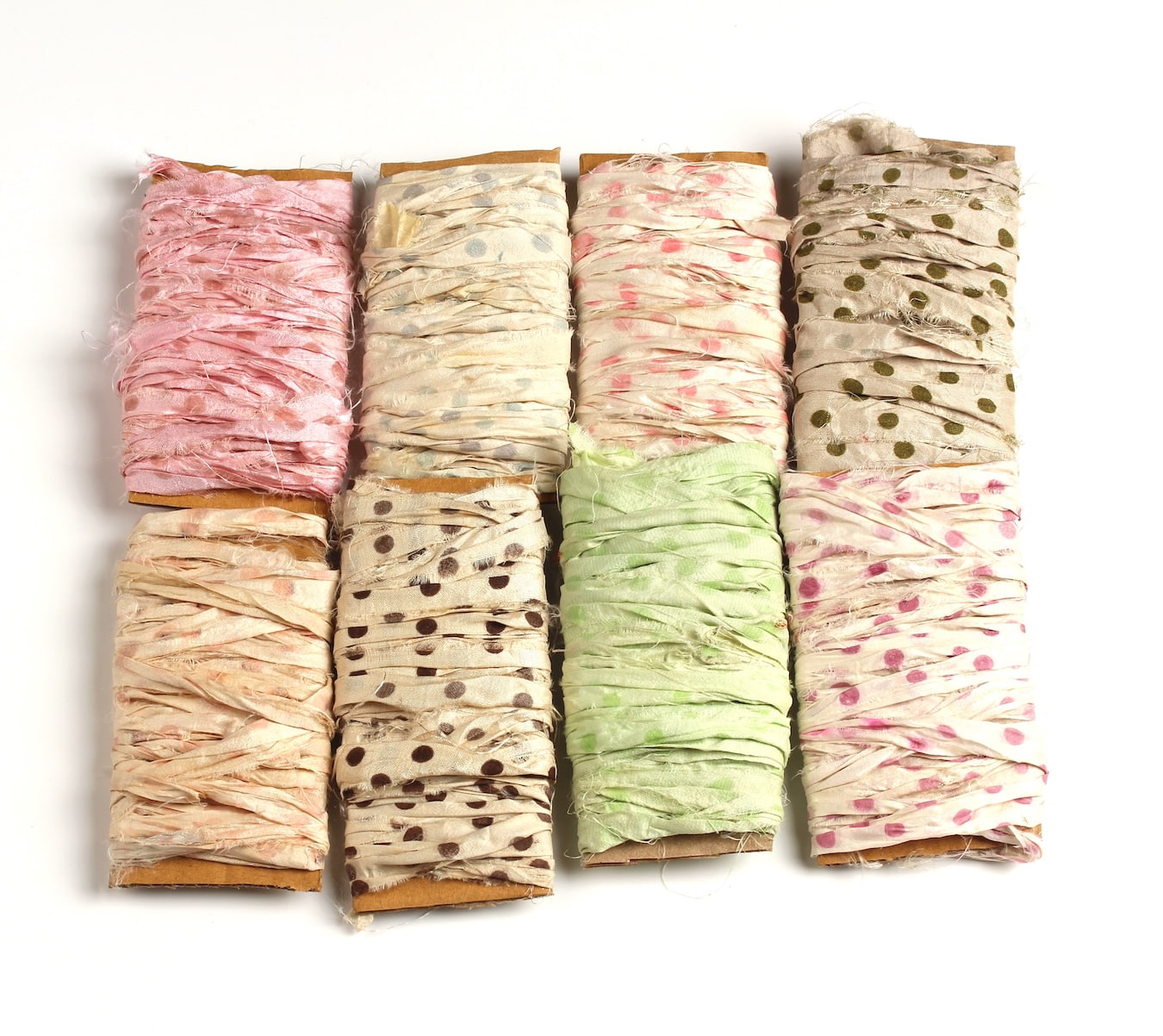 Eight assorted polka dot sari silk ribbons in different shades on cardboard display