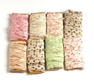 Eight assorted polka dot sari silk ribbons in different shades on cardboard display