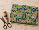 Hand block printed cotton fabric with pink flowers and indigo foliage on an apple green background