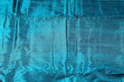 Turquoise Blue Dupion Silk Fabric arranged in elegant folds highlighting its iridescent sheen, crisp texture, and vibrant blue-green tones
