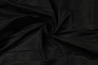 Black Dupion Silk Fabric arranged in elegant swirling folds highlighting its luxurious sheen, crisp texture, and deep black colouring