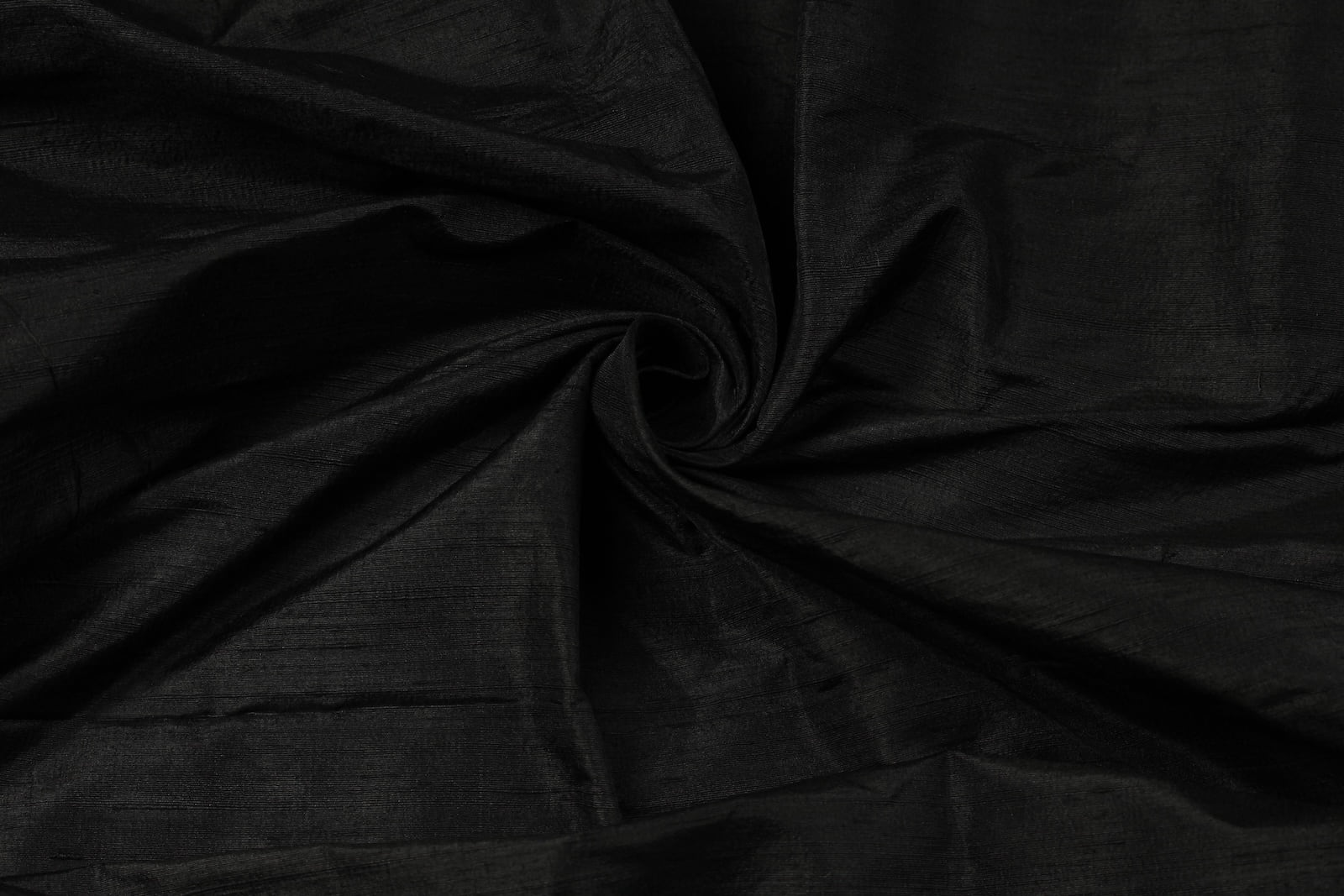 Black Dupion Silk Fabric arranged in elegant swirling folds highlighting its luxurious sheen, crisp texture, and deep black colouring