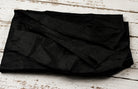 Black Dupion Silk Fabric displayed with flowing folds revealing natural slub texture and sophisticated black silk finish