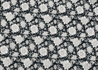 Black and white floral block printed cotton fabric featuring a repeating botanical pattern