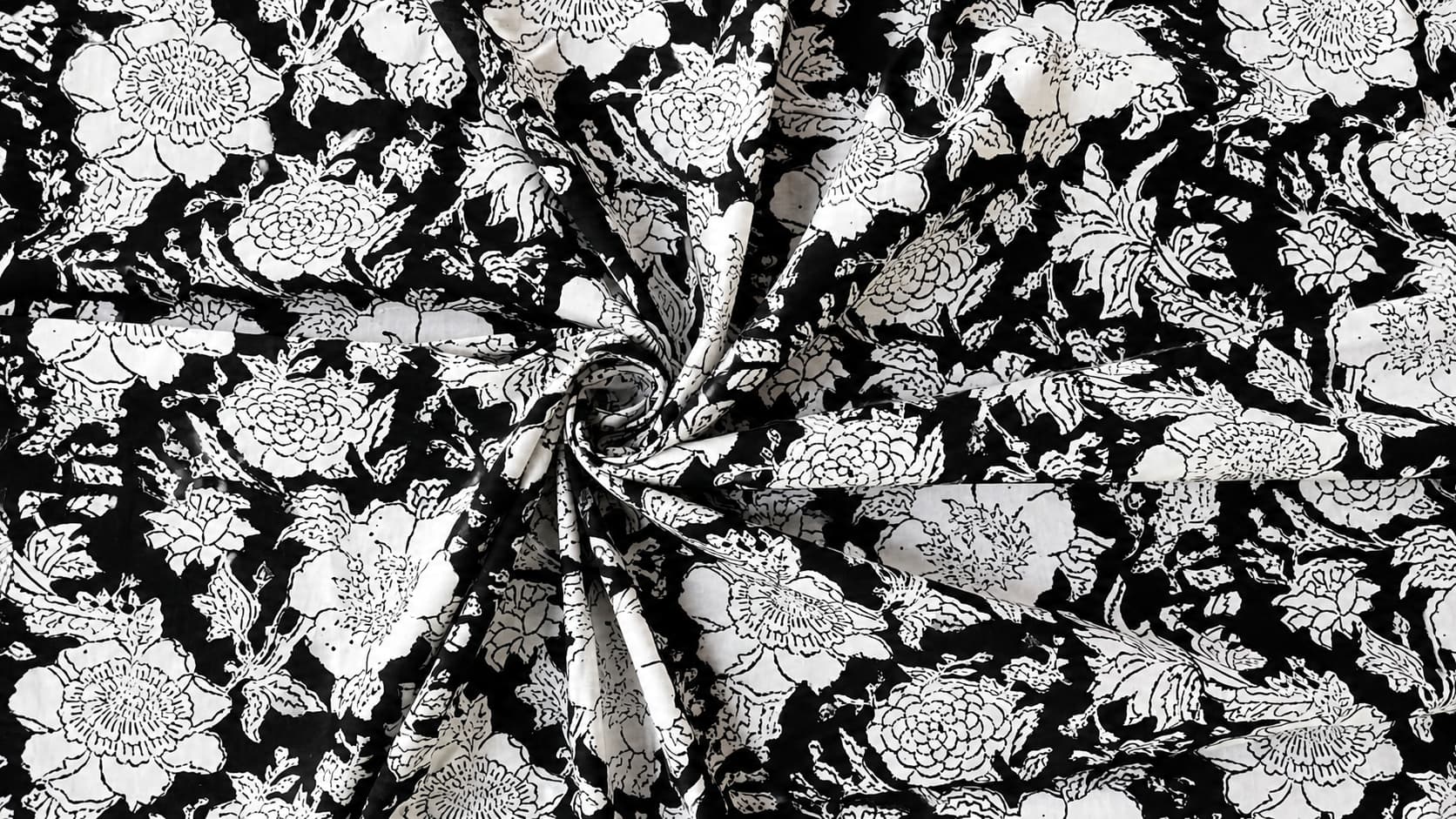 Black and white floral block printed cotton fabric draped to show pattern and texture