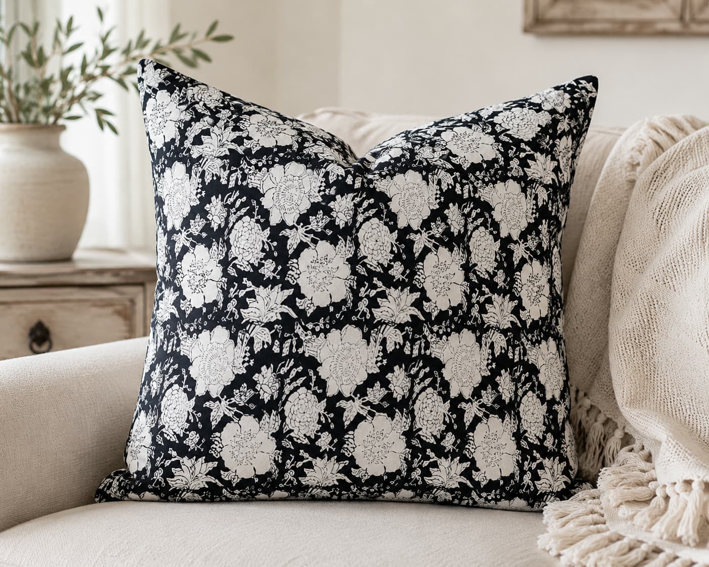 Black and white floral block printed cotton fabric used for a decorative cushion cover