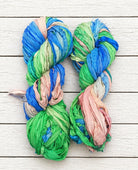 Full skein of Seaside Garden sari silk ribbon yarn in blue, green and blush tones