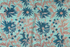 Close-up of blue floral blooms and delicate vine details on aqua hand block printed cotton fabric