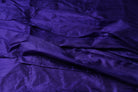 Blue Violet Dupion Silk Fabric displayed with soft folds revealing natural silk texture, luminous finish, and vibrant blue-violet tones