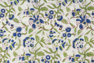 Close-up of blue floral motifs and green leafy vines on hand block printed cotton fabric