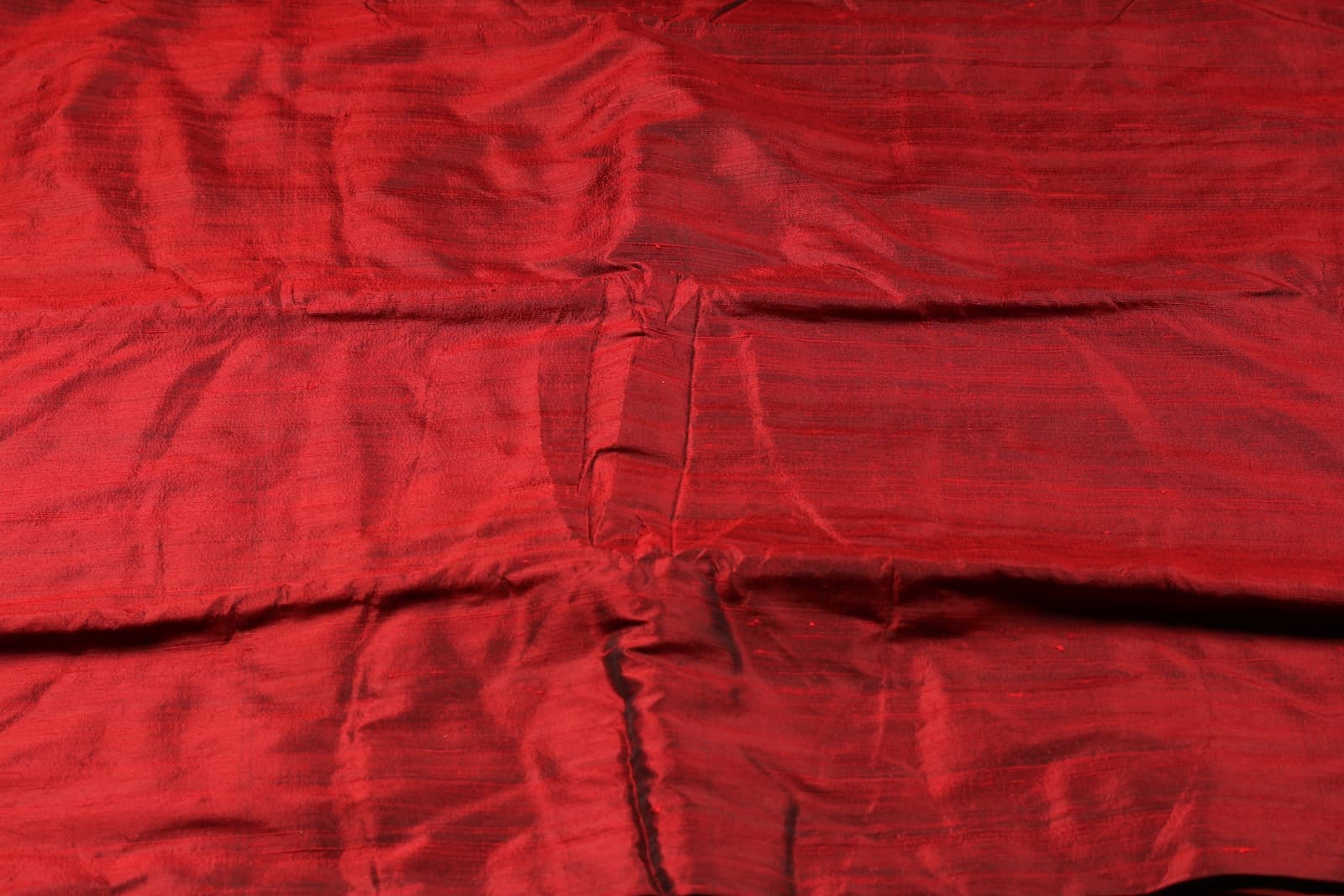 Bordeaux Red Dupion Silk Fabric laid flat displaying its luxurious colour, subtle sheen, and natural dupion silk texture