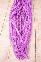 Orchid sari silk ribbon in loose strands showing soft texture and naturally frayed edges.