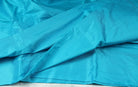 Turquoise  Dupion Silk Fabric displayed in flowing folds showing its vibrant colour and luxurious silk sheen