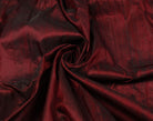 Ruby red Dupion silk fabric arranged to highlight texture, sheen and drape.