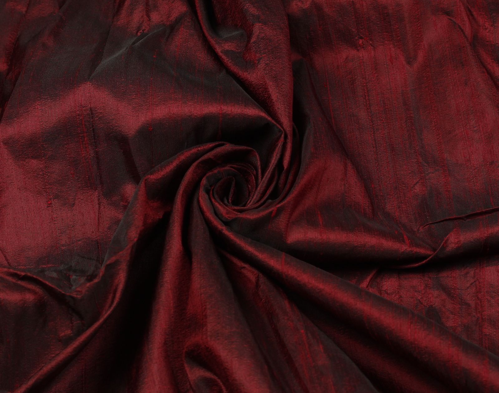 Ruby red Dupion silk fabric arranged to highlight texture, sheen and drape.