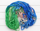Loose strands of Seaside Garden recycled silk ribbon yarn with ocean-inspired colors
